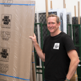 Michael Holding Security Screen Door in Warehouse Cover Image